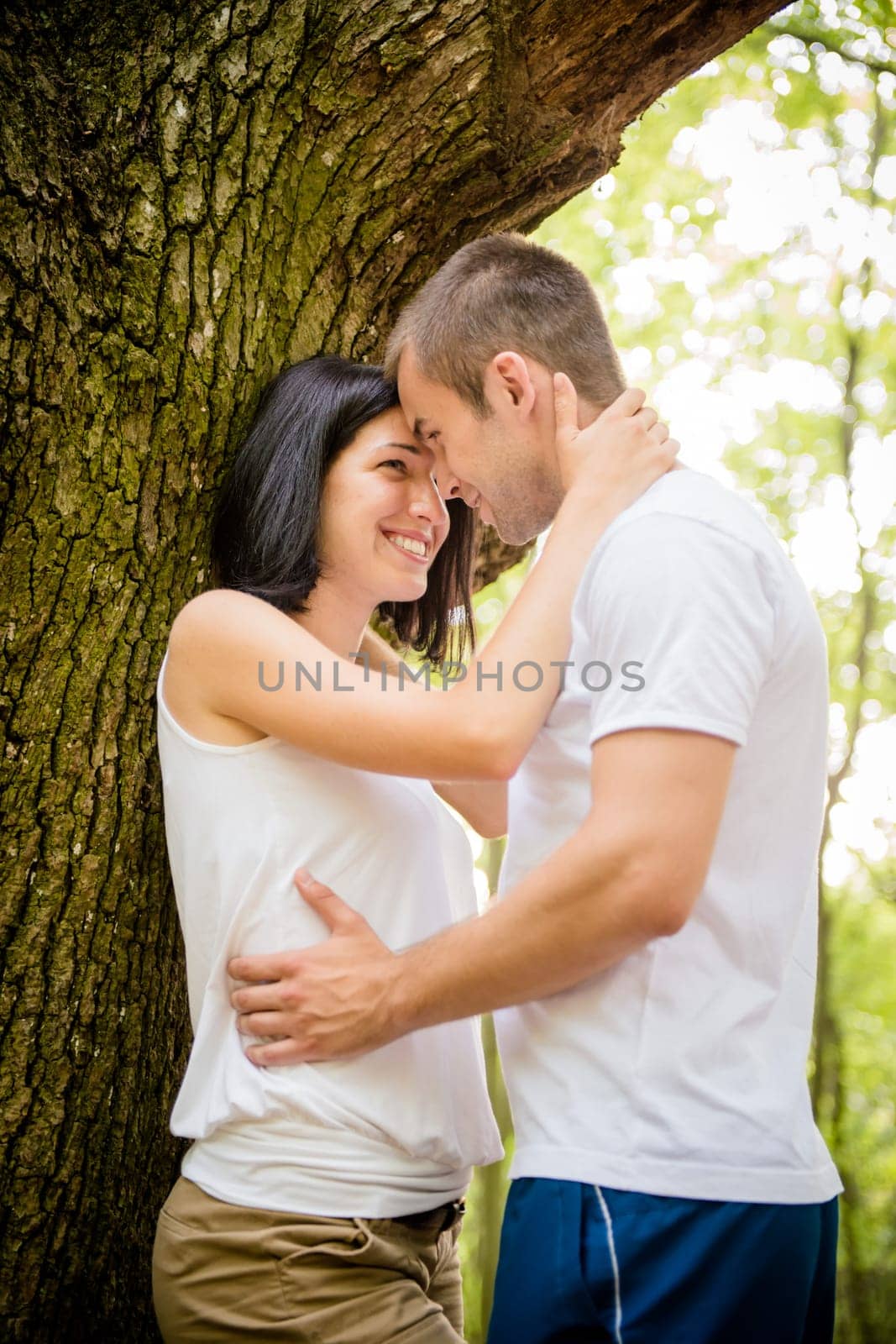 Young couple in love together in nature at tree