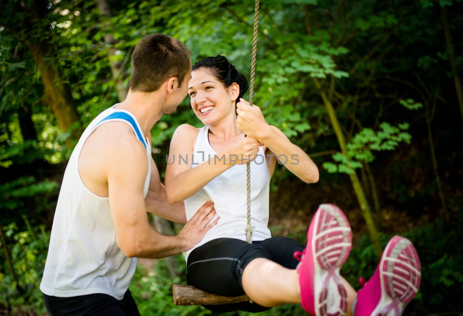 Young sport couple having fun - swinging on seesaw