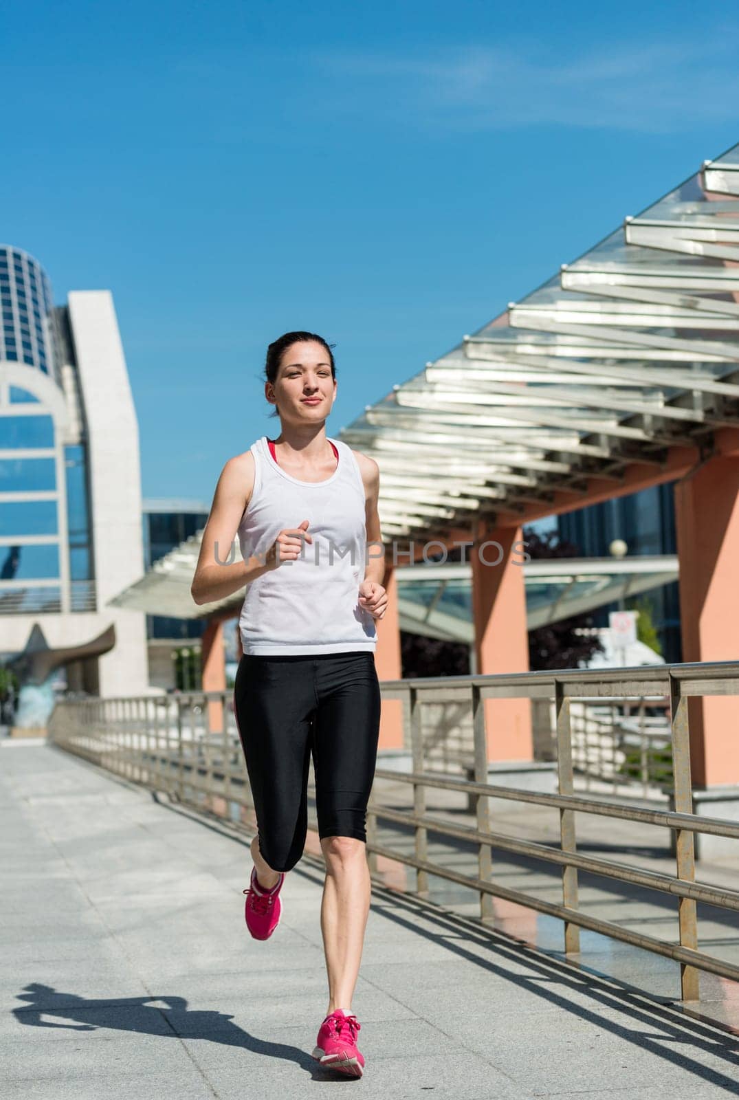 Running lifestyle - young sport woman jogging in street
