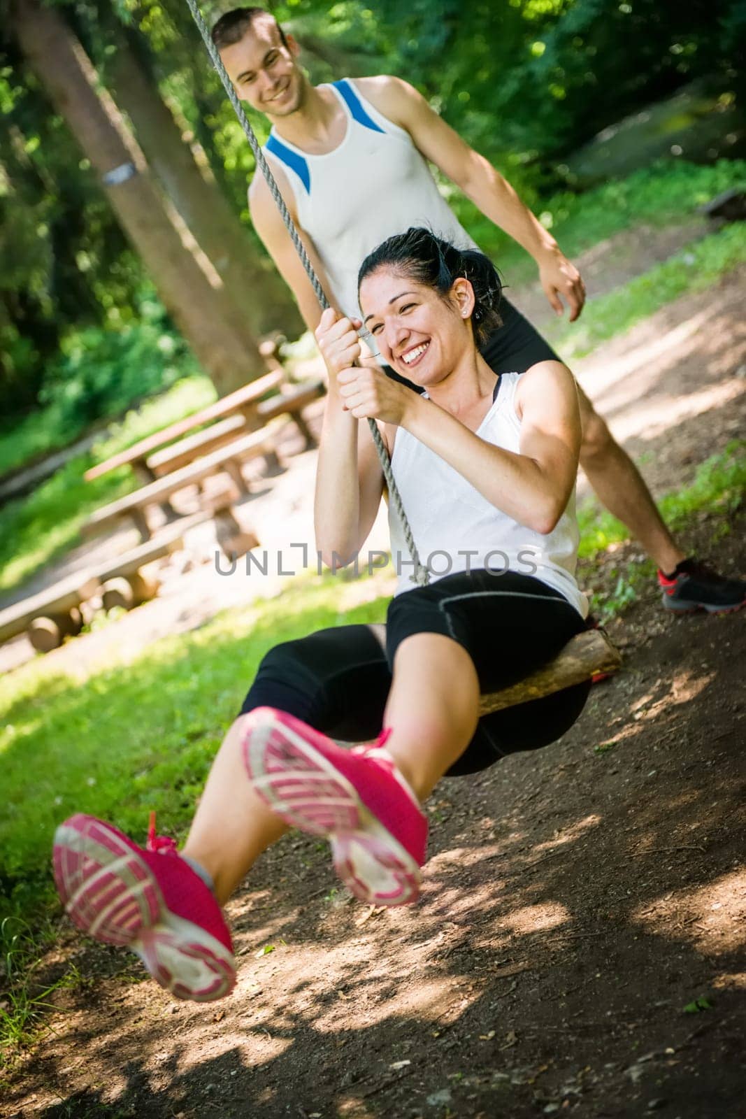 Young sport couple having fun - swinging on seesaw