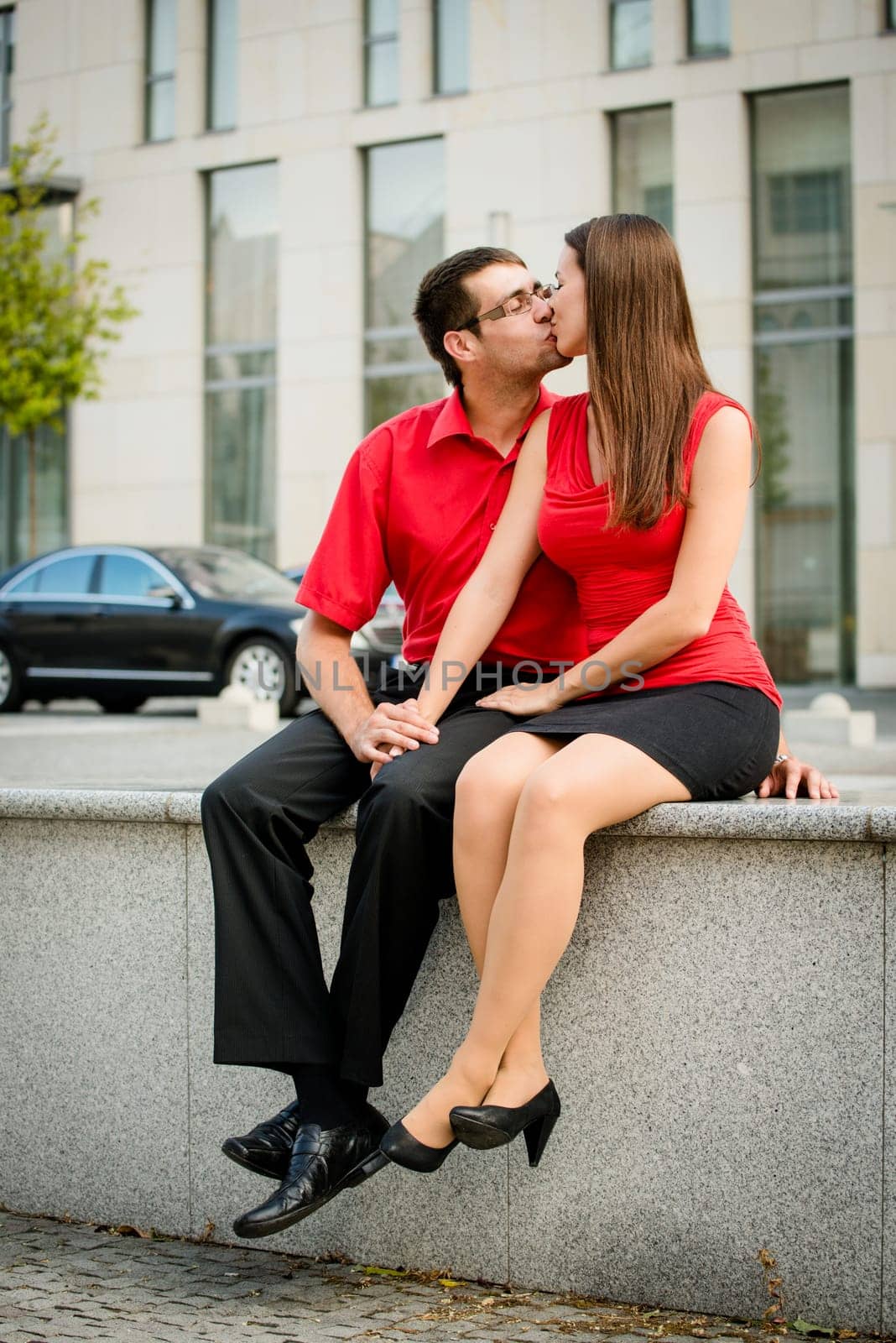 Lifestyle photo of young kissing business people outdoor in street