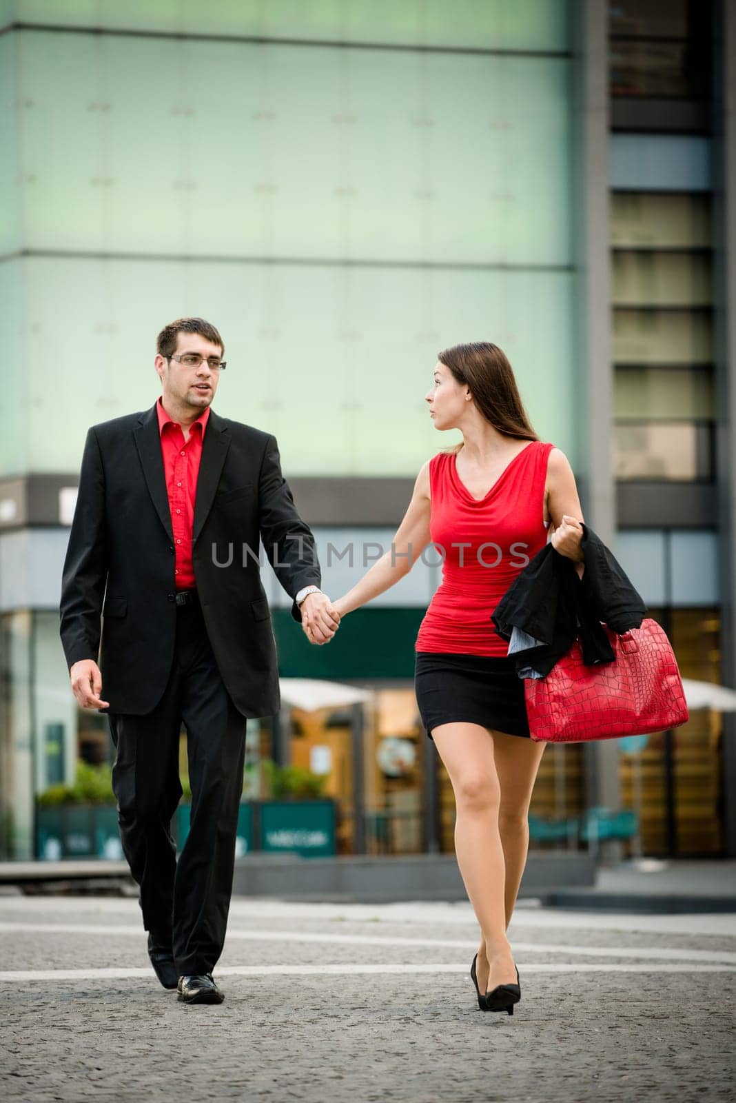 Hurry - young business woman draging her boyfriend on street
