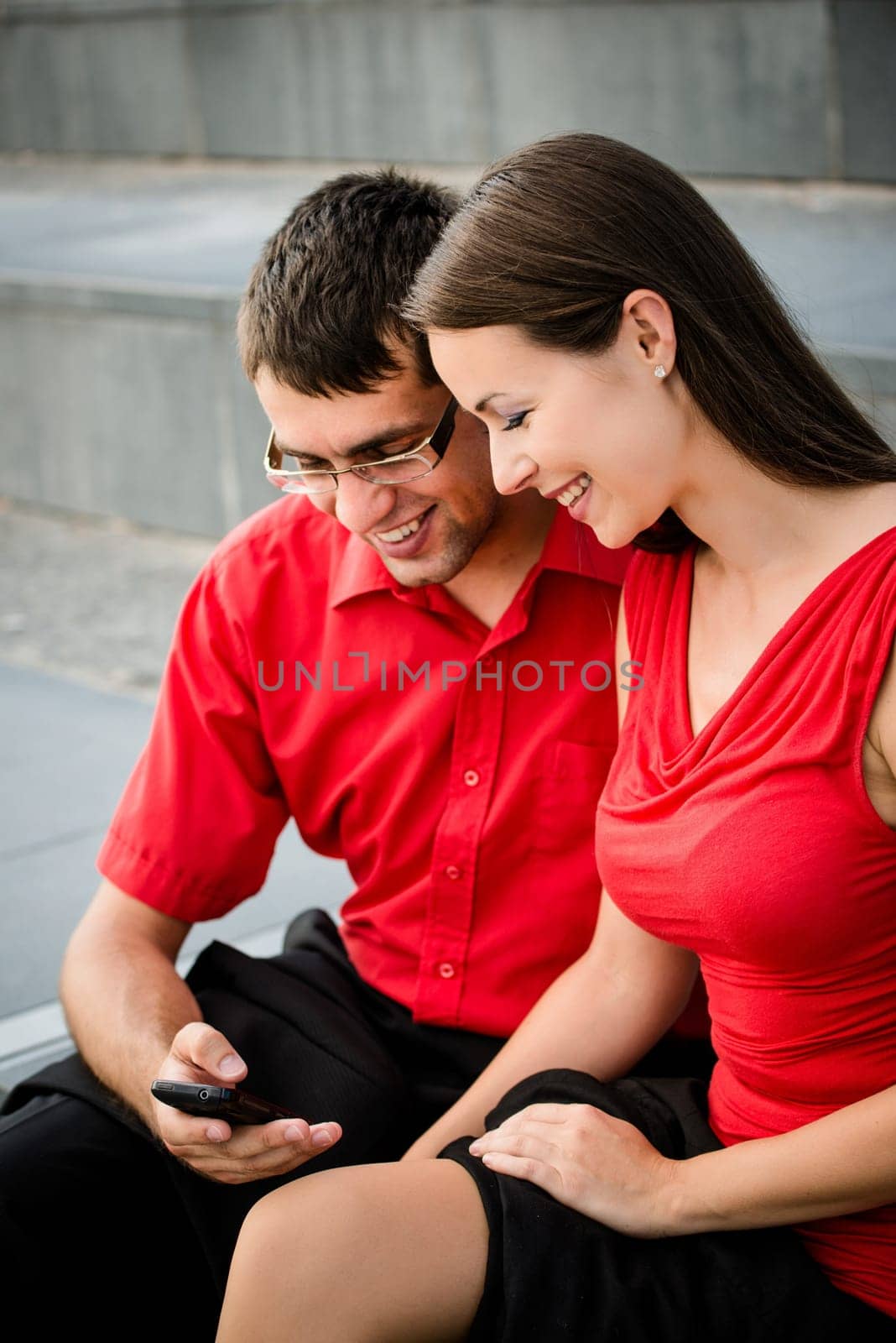 Colleagues - young business people having conversation and showing something on mobile phone
