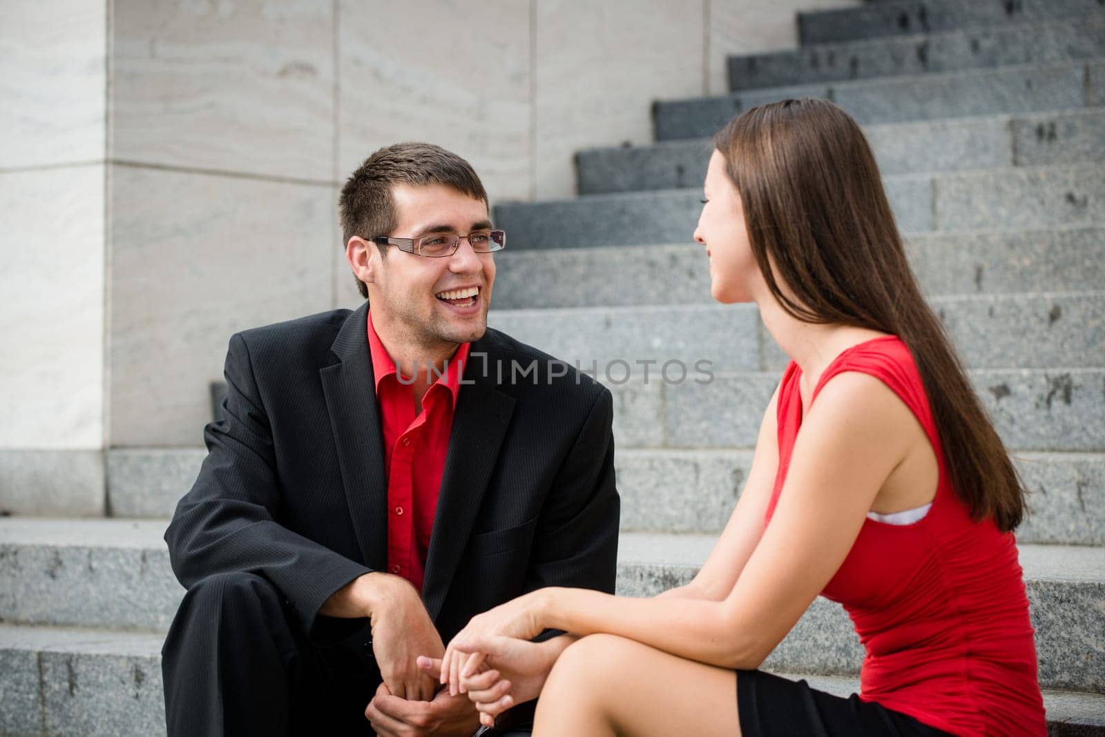 Colleagues - young business people having conversation sitting on stairs
