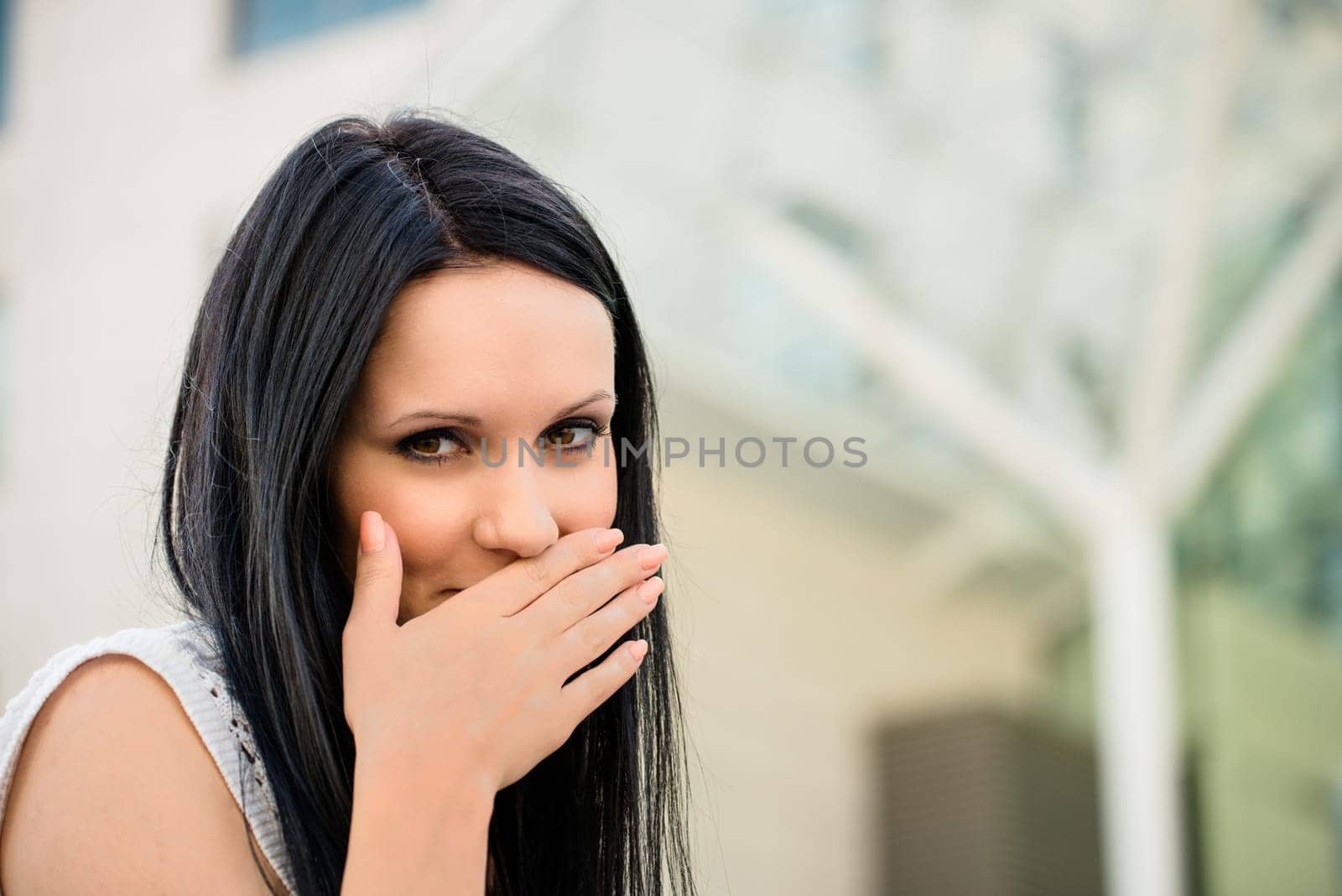 Young beautiful woman covering mouth with hand