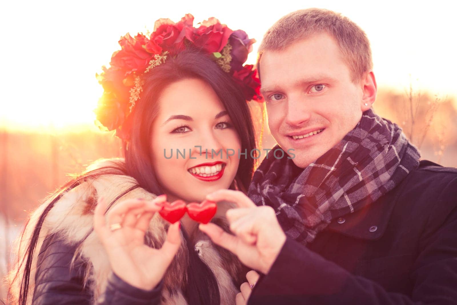Young couple are holding pair of hearts as a symbol of their love