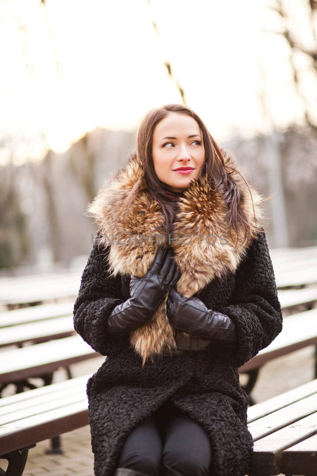 Young professional lady in the park is enjoying winter