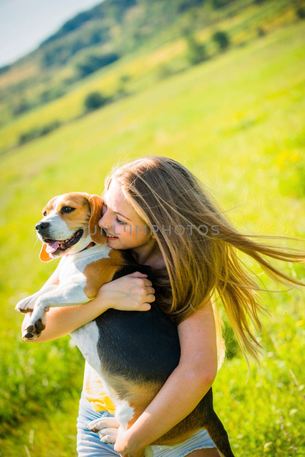 Teen girl holding her pet (beagle dog) - outdoor in nature