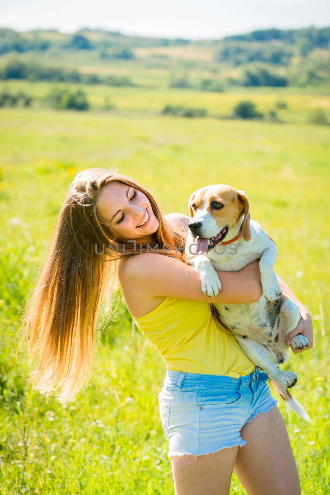 Teen girl holding her pet (beagle dog) - outdoor in nature