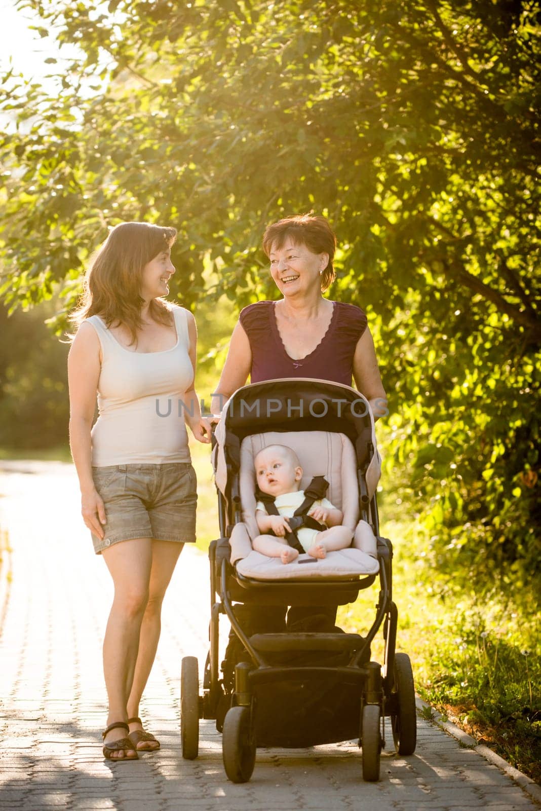 On a walk - grandmother with her daughter and her granddaughter in stroller