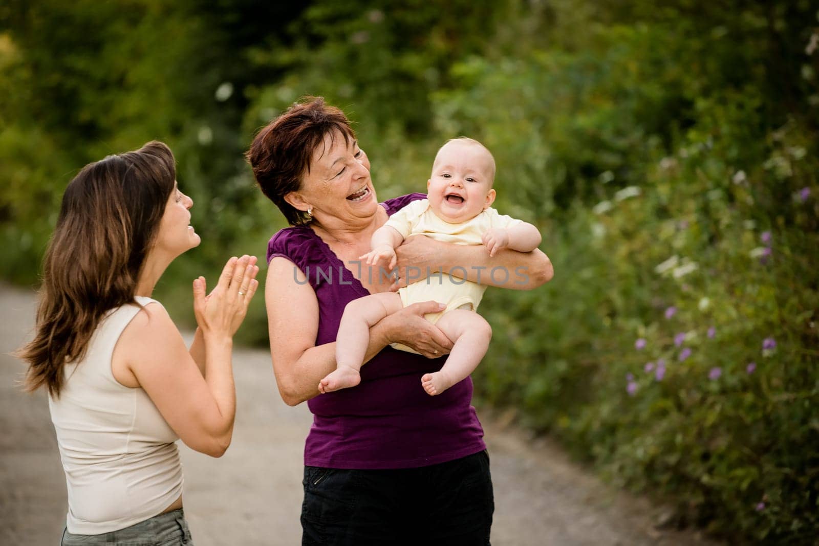 Happy together - grandmother with her daughter and her granddaughter outdoor in nature