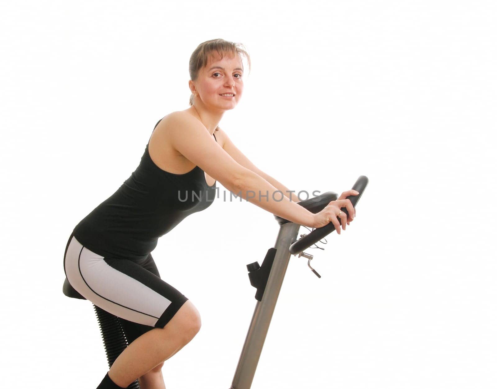 Young fitness woman exercising on spinning bicycle from back - isolated on white background