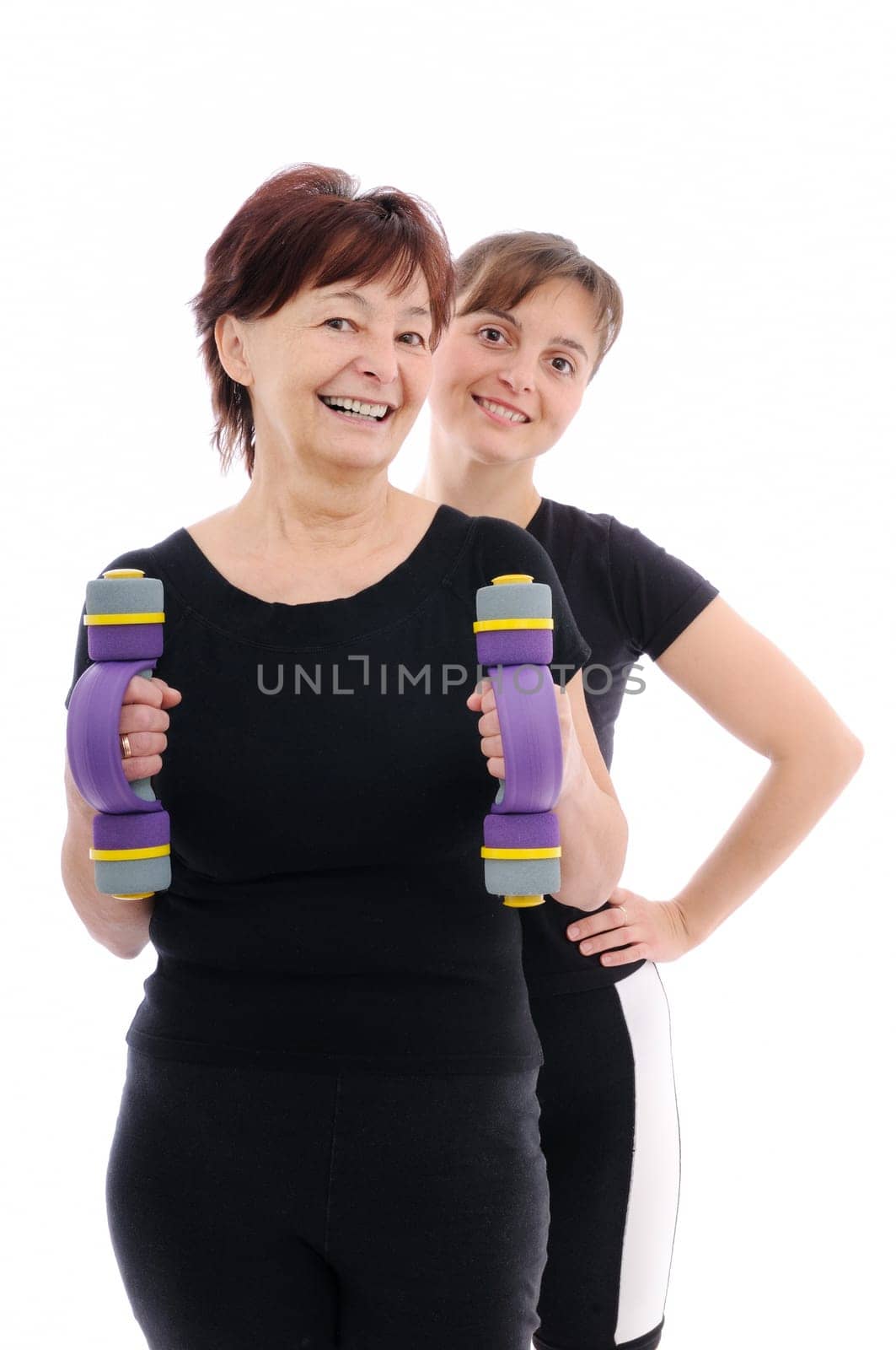 Senior woman  exercising with barbells assisted by trainer