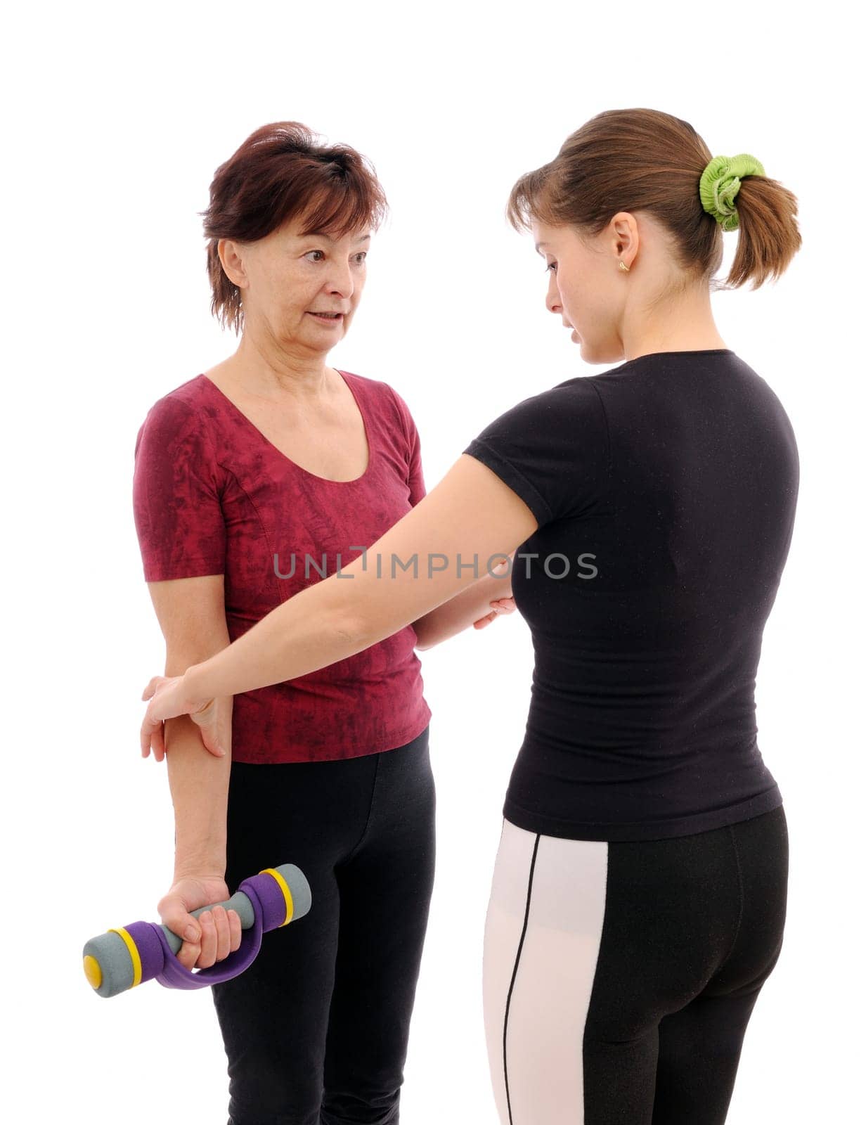 Senior woman  exercising with barbells assisted by trainer
