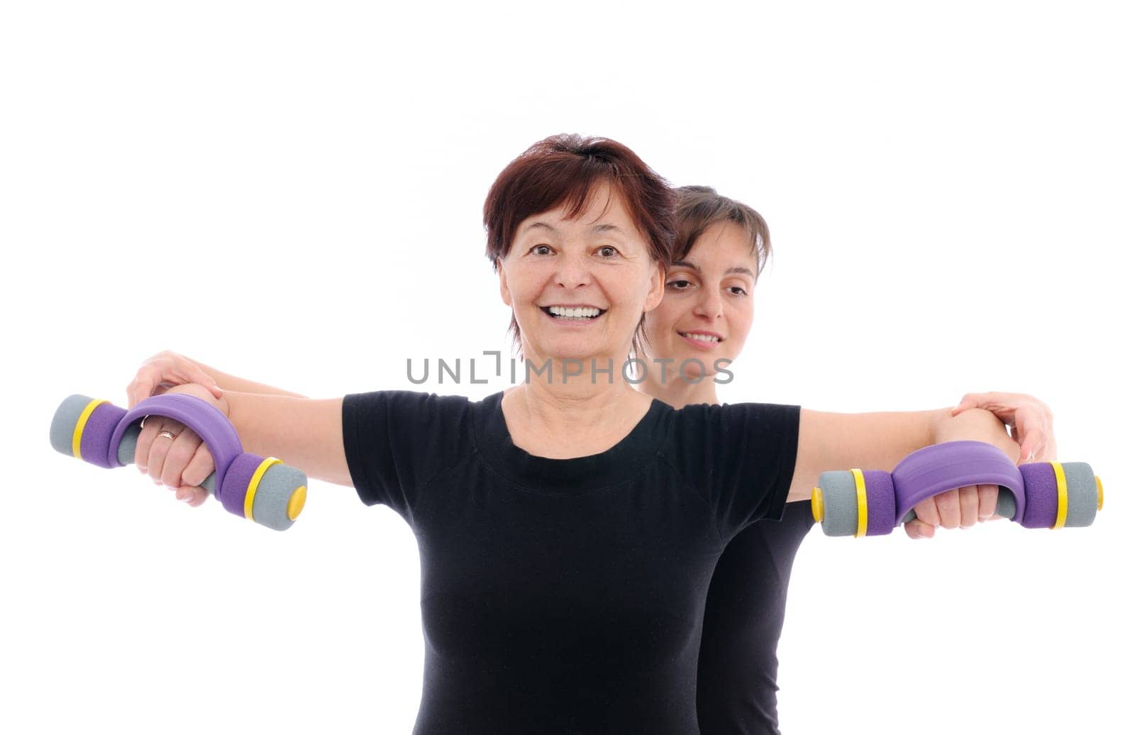 Senior woman  exercising with barbells assisted by trainer