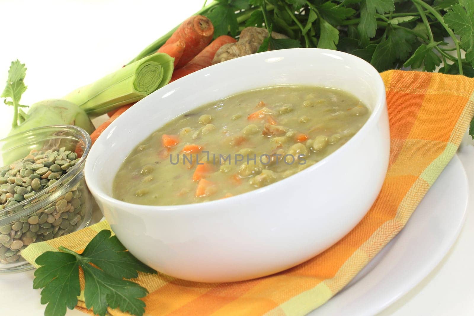 a white bowl with pea stew and parsley