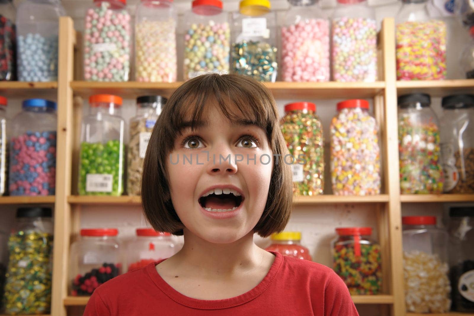 young girl looking in awe at rows of sweets
