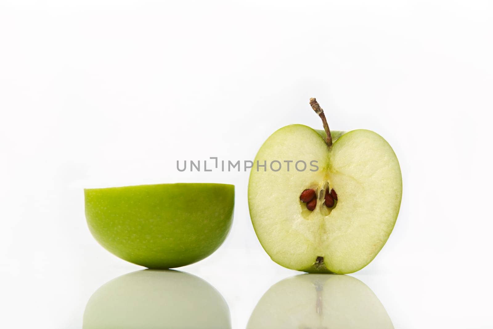 Studio shot of green apple cut in half showing seeds