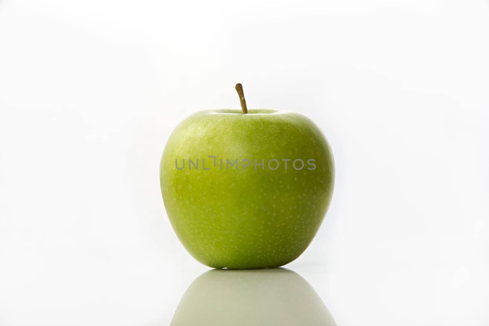 Studio shot of green apple on white background with reflection