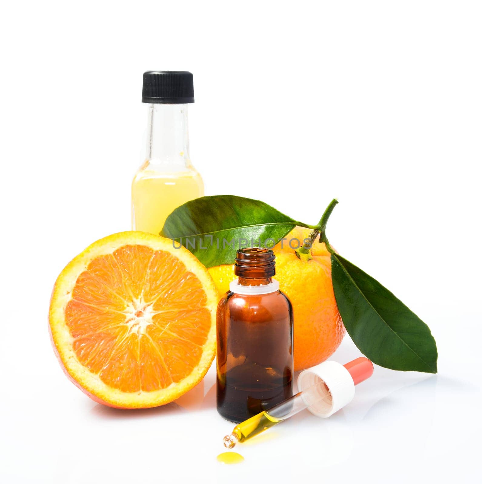 Orange with green leaves and a bottle with dropper isolated on a white background. Alternative medicine concept
