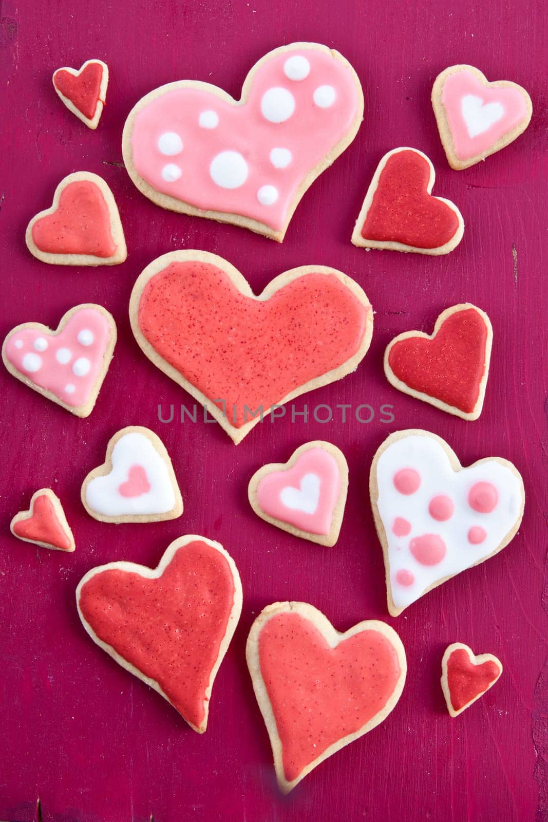 Colorful hearts on a red wooden background