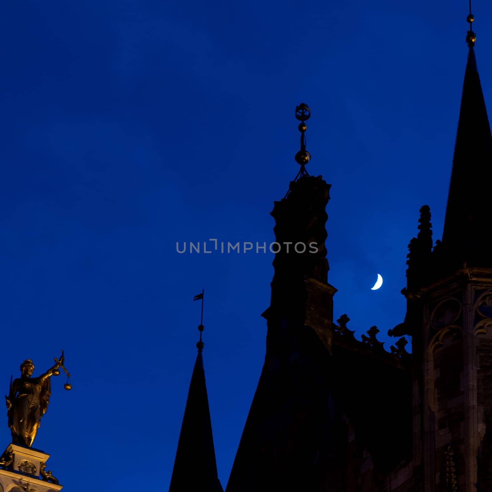 Towers and façade of Bruges Town Hall in the moonlight