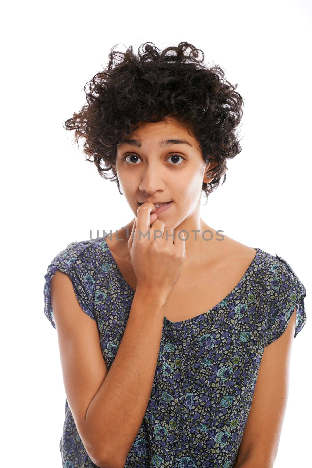 Portrait of confused and uncertain hispanic woman biting nail on white background and looking at camera