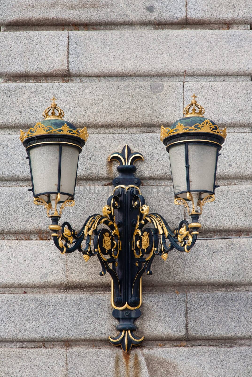 Ornate gilded lamp post at the Royal Palace in Madrid, Spain .