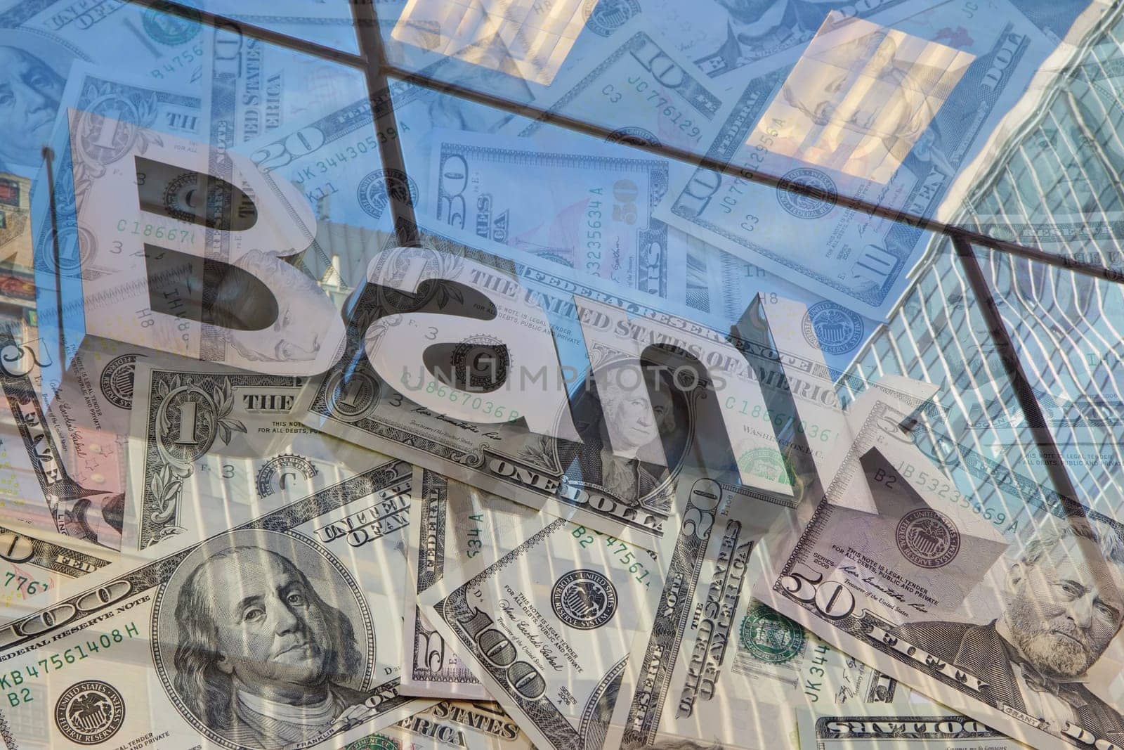 The glass wall of the building with the inscription Bank and U.S dollar notes
