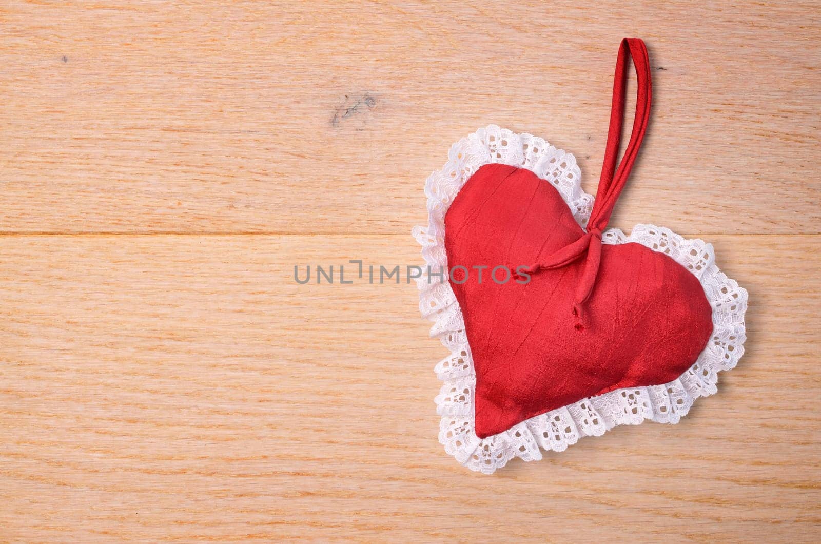 Red heart shape on a wooden background with space for text