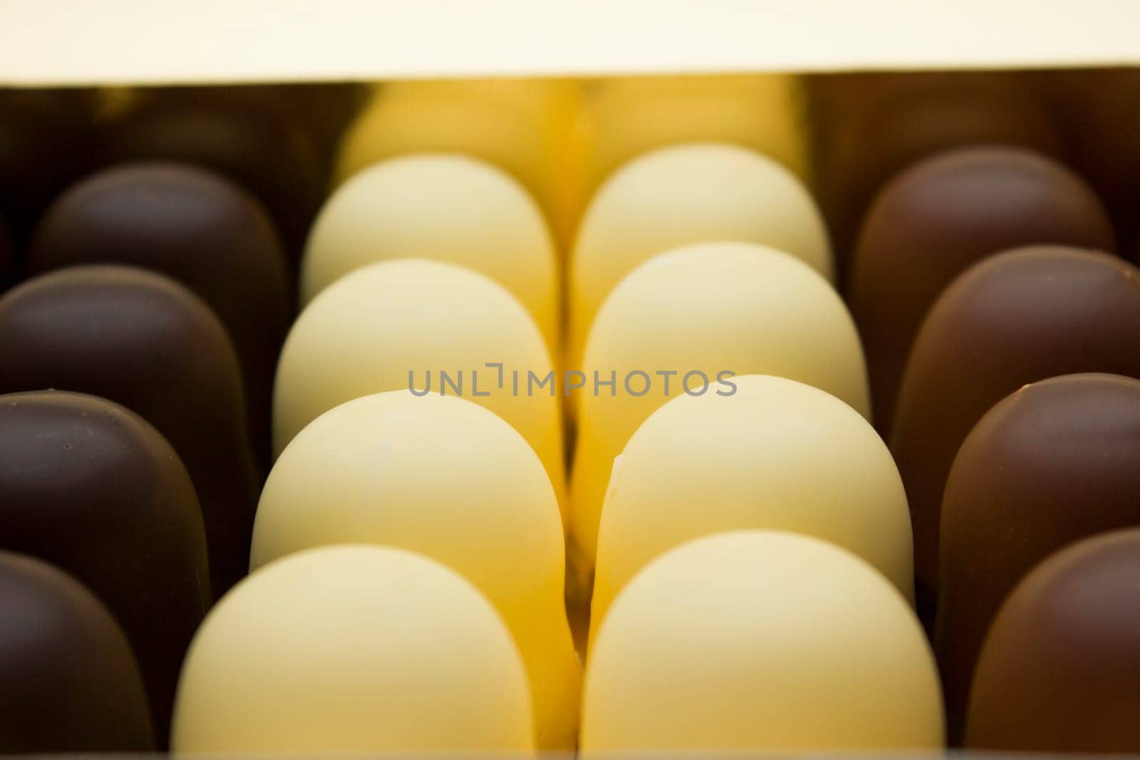 Chocolate covered dark brown, light brown and white marshmallows.