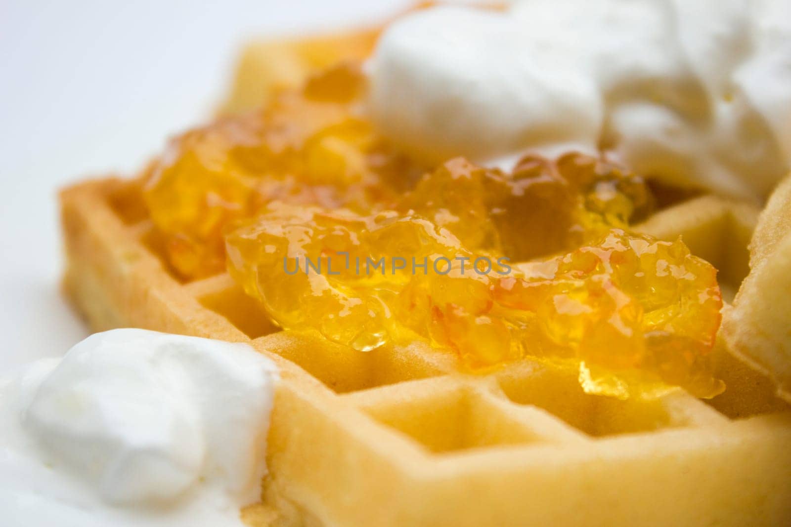 Toasted waffles with orange jam and cream on top.