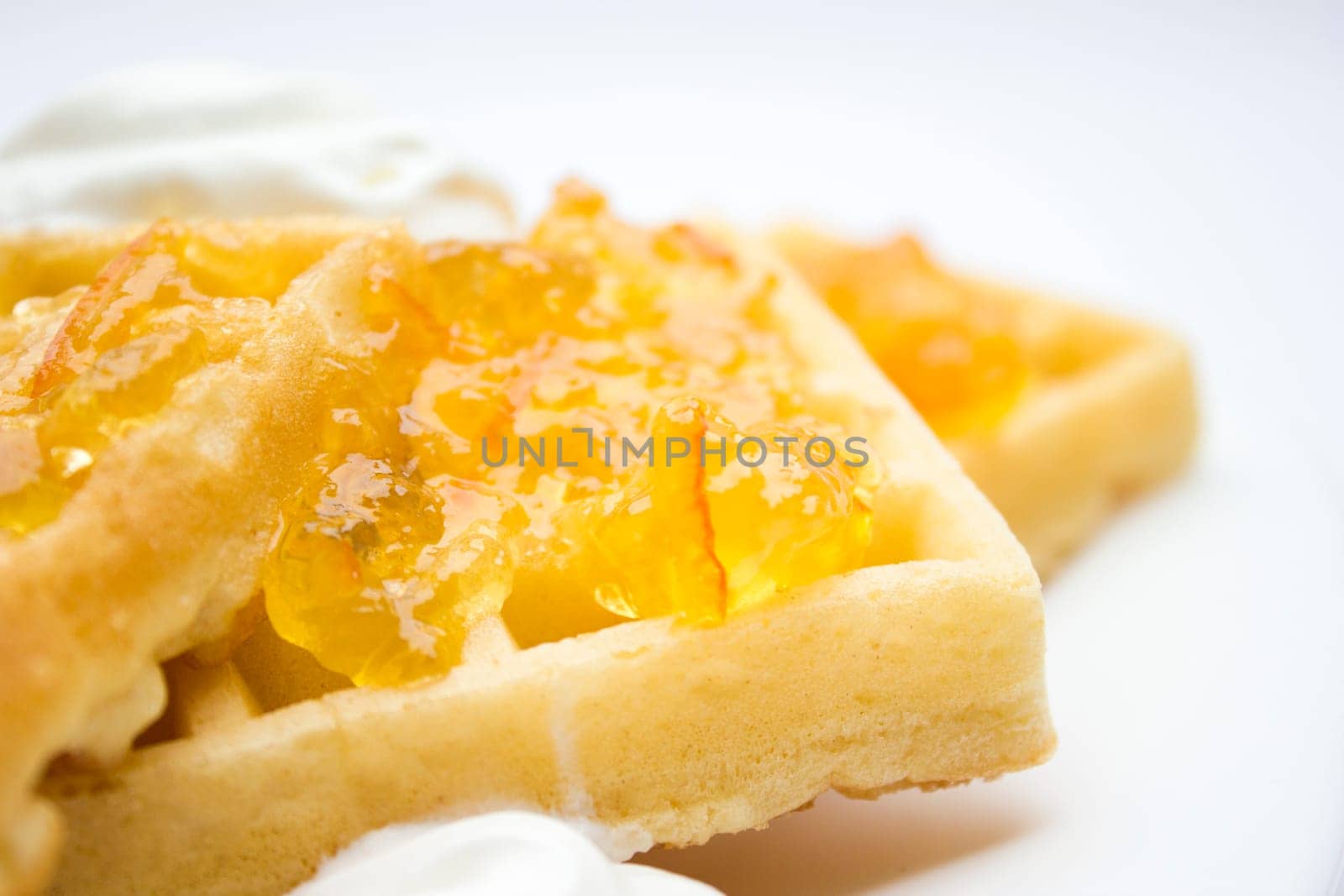 Toasted waffles with orange jam and cream on top.