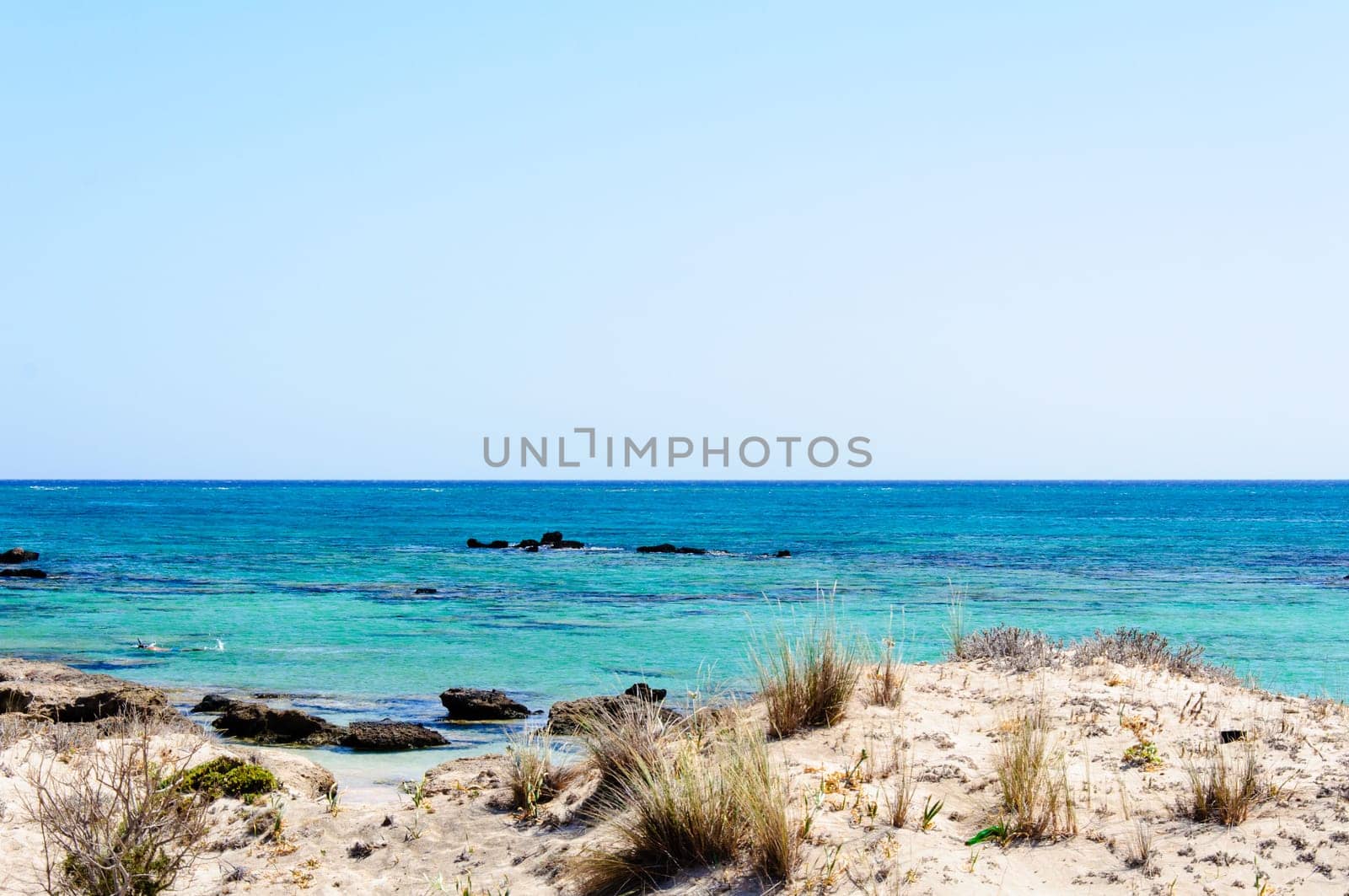 Elafonisi or Elafonissi, "deer island"" in Greek, is an island located close to the southwestern corner of the Mediterranean island of Crete, Greece. Elafonisi is an oblong, which often ""breaks"" in two parts by water giving the impression of being a separate island. The island is a protected nature reserve."