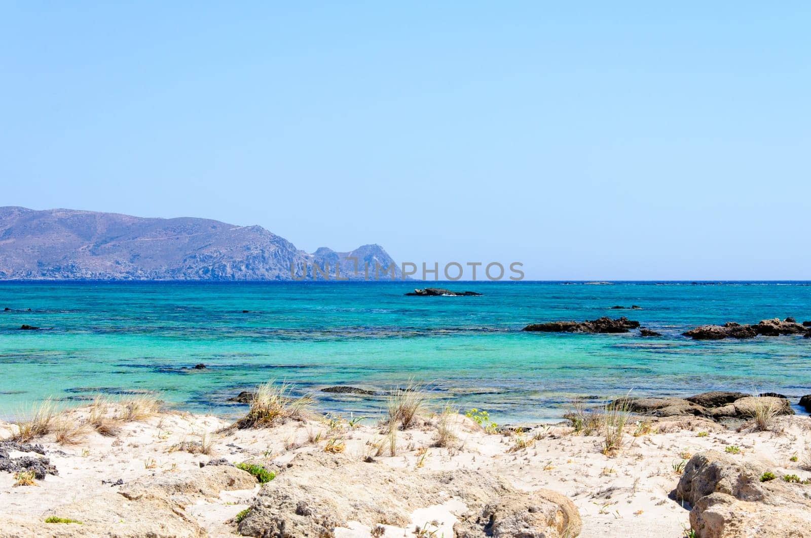 Elafonisi or Elafonissi, "deer island"" in Greek, is an island located close to the southwestern corner of the Mediterranean island of Crete, Greece. Elafonisi is an oblong, which often ""breaks"" in two parts by water giving the impression of being a separate island. The island is a protected nature reserve."