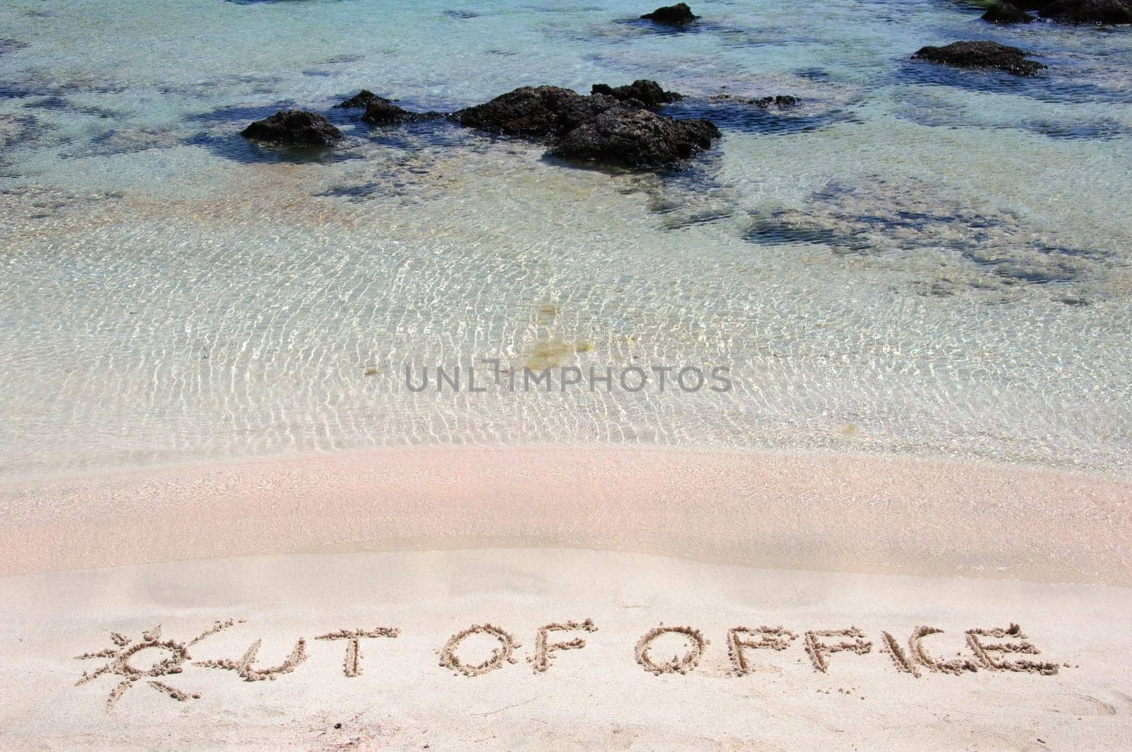 OUT OF OFFICE written on sand on a beautiful beach, blue waves in background .Relax concept image