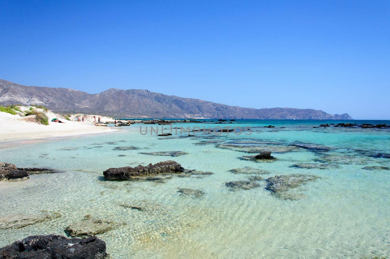 Elafonisi or Elafonissi, "deer island"" in Greek, is an island located close to the southwestern corner of the Mediterranean island of Crete, Greece. Elafonisi is an oblong, which often ""breaks"" in two parts by water giving the impression of being a separate island. The island is a protected nature reserve."