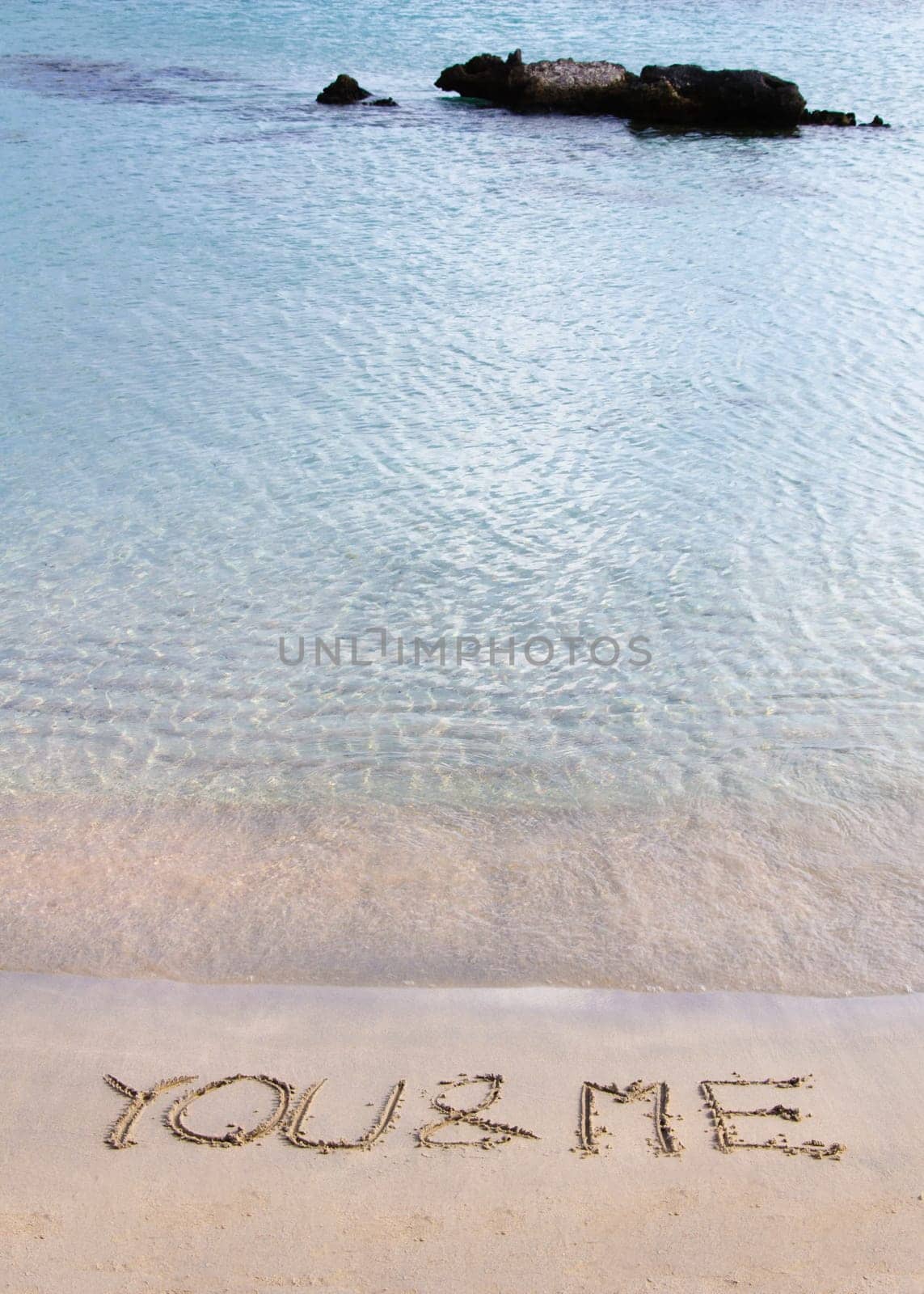 You and me message written in the sand on a beautiful  beach