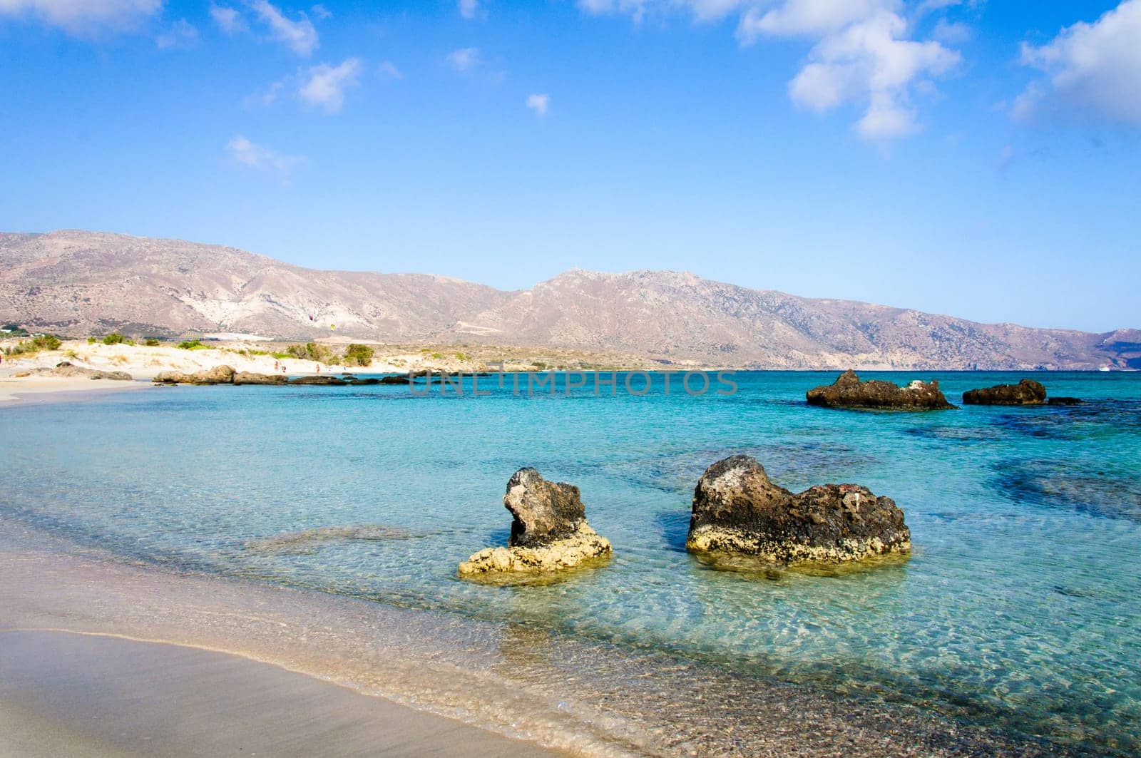 Elafonisi or Elafonissi, "deer island"" in Greek, is an island located close to the southwestern corner of the Mediterranean island of Crete, Greece. Elafonisi is an oblong, which often ""breaks"" in two parts by water giving the impression of being a separate island. The island is a protected nature reserve."