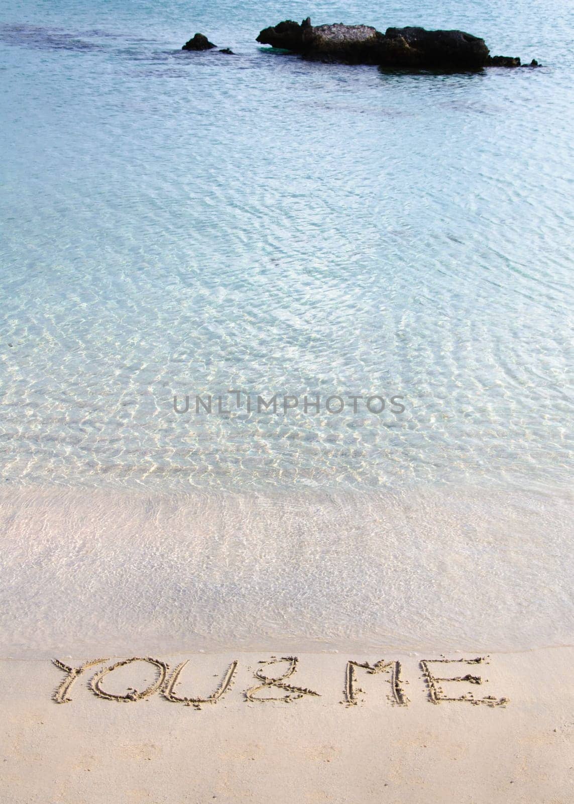 You and me message written in the sand on a beautiful  beach