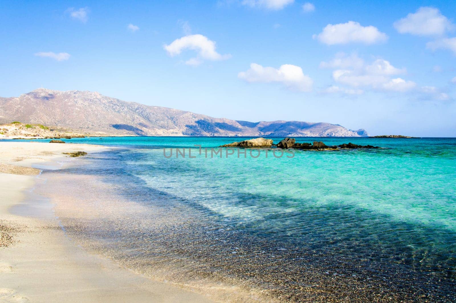 Elafonisi or Elafonissi, "deer island"" in Greek, is an island located close to the southwestern corner of the Mediterranean island of Crete, Greece. Elafonisi is an oblong, which often ""breaks"" in two parts by water giving the impression of being a separate island. The island is a protected nature reserve."