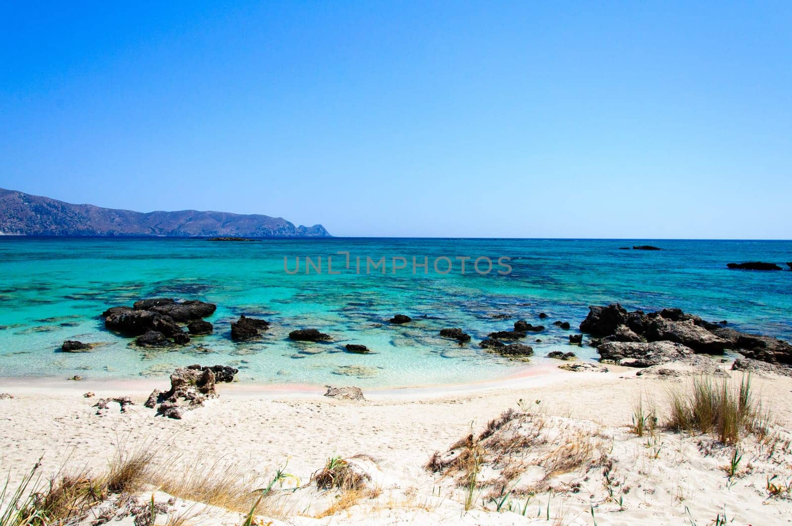 Elafonisi or Elafonissi, "deer island"" in Greek, is an island located close to the southwestern corner of the Mediterranean island of Crete, Greece. Elafonisi is an oblong, which often ""breaks"" in two parts by water giving the impression of being a separate island. The island is a protected nature reserve."