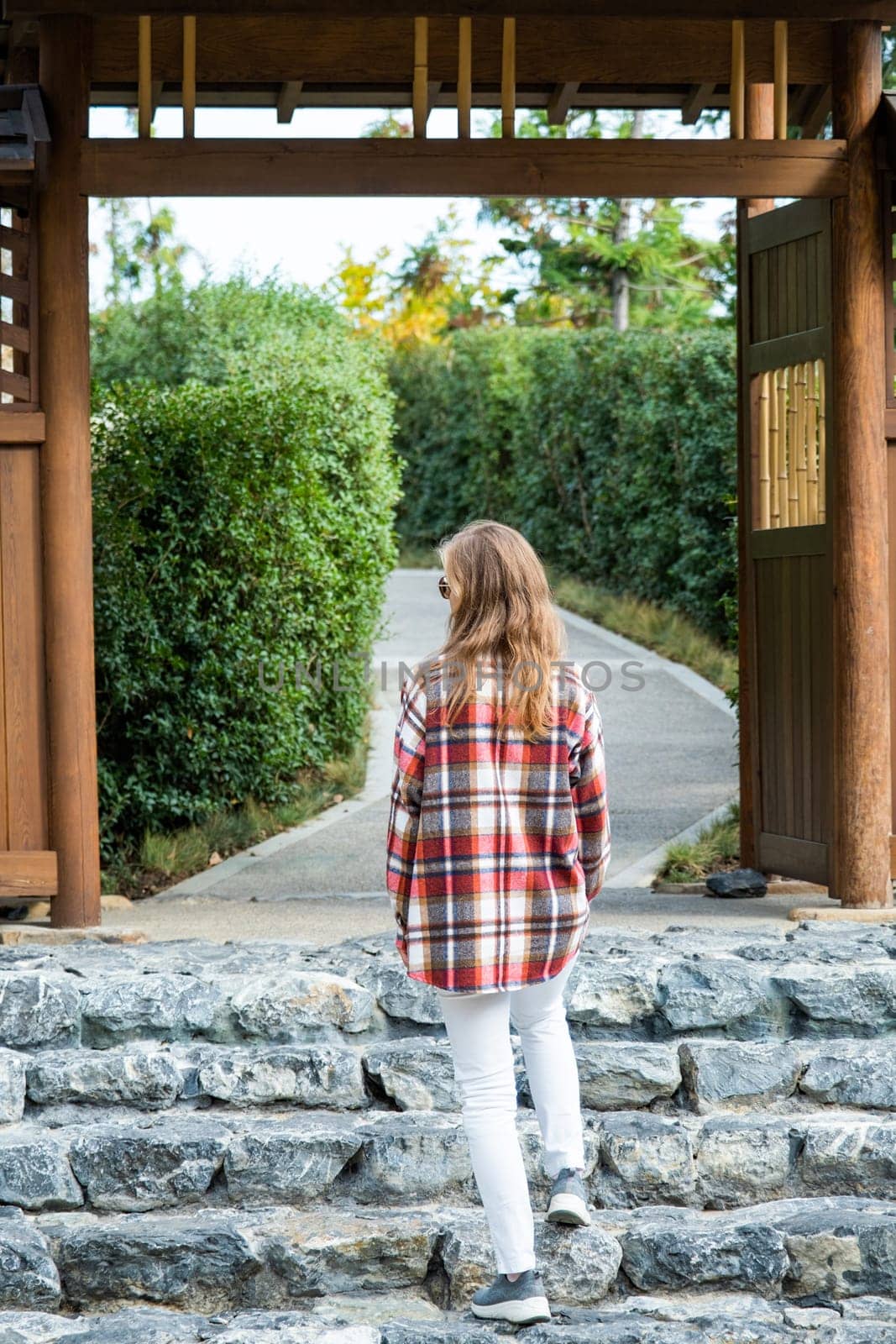 Woman enjoying nature walking in Japanese Garden by Desperada