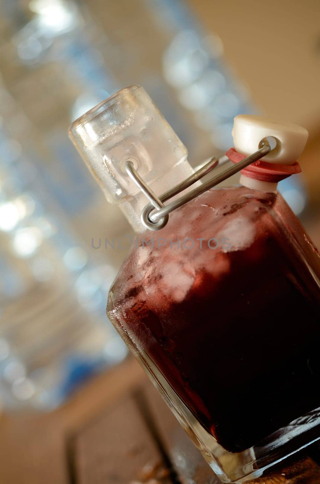 Cold bottle with juice of cherries and chrushed ice cubes