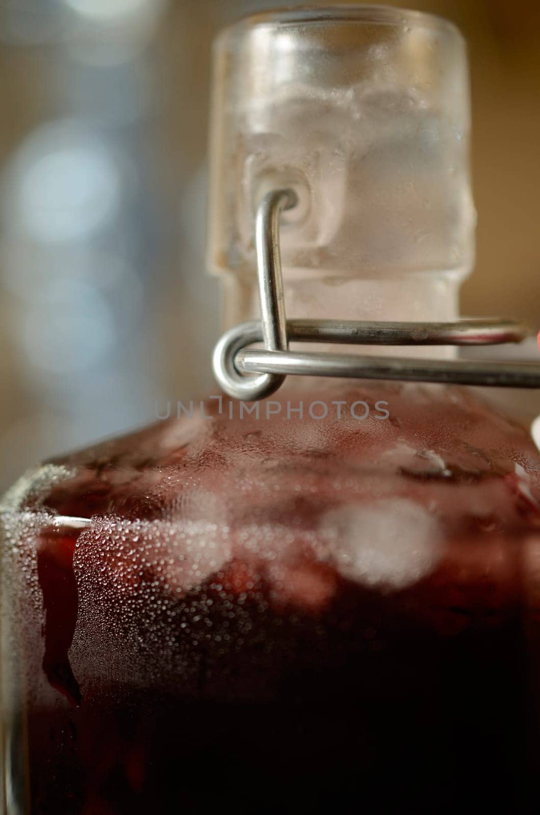 Cold bottle with juice of cherries and chrushed ice cubes
