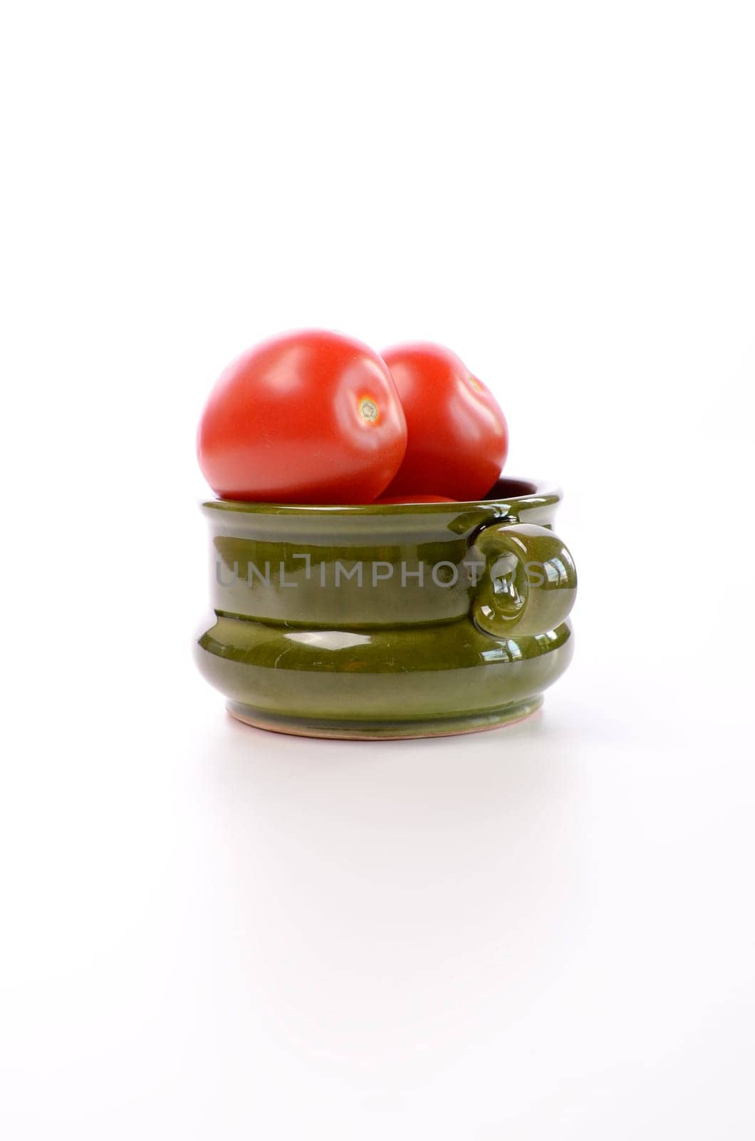 Fresh red roma tomatoes in a green ceramic bowl