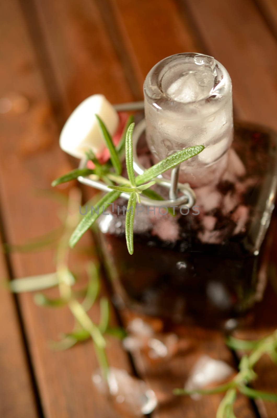 Cold bottle with juice of cherries and chrushed ice cubes