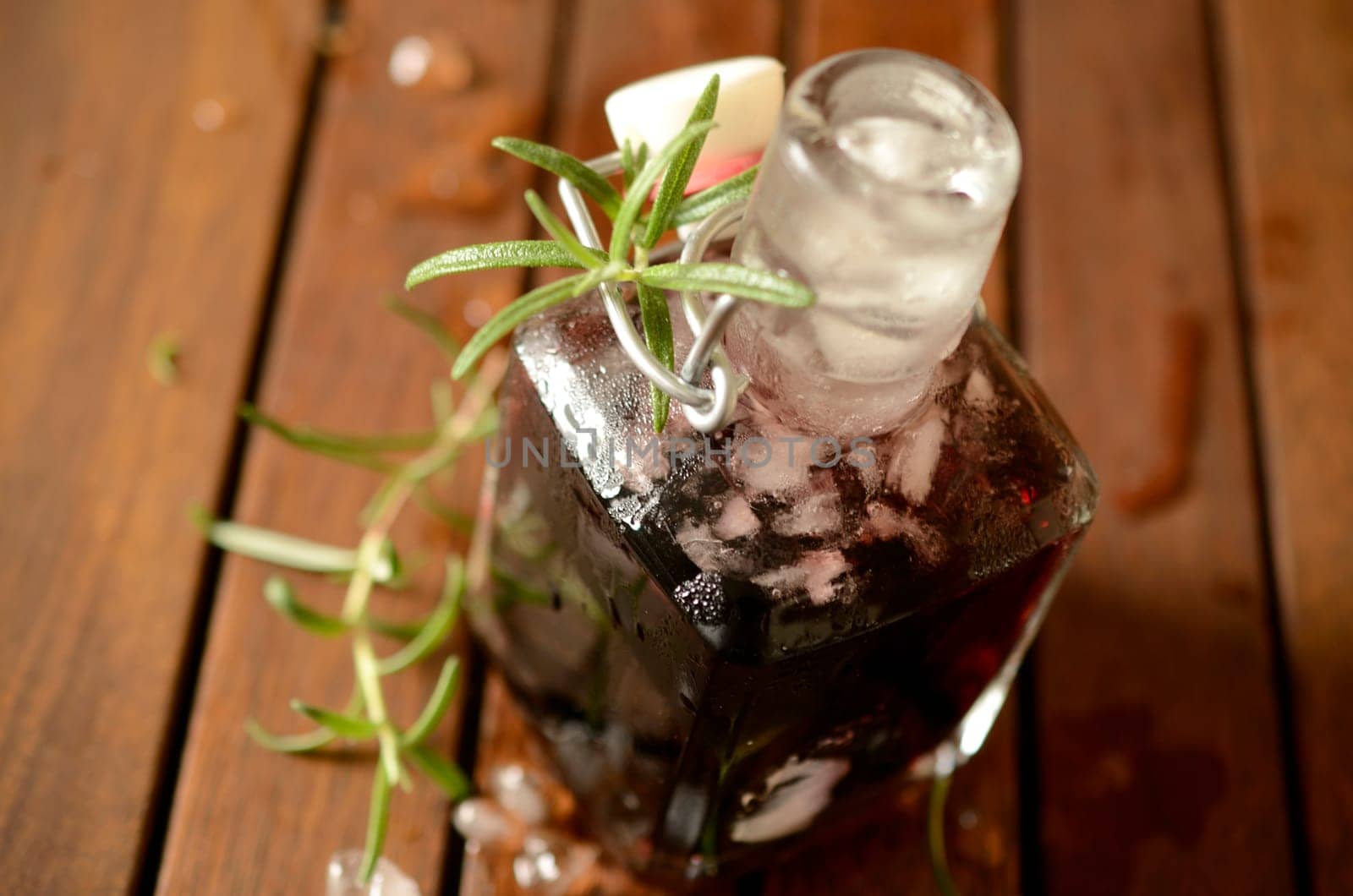 Cold bottle with juice of cherries and chrushed ice cubes