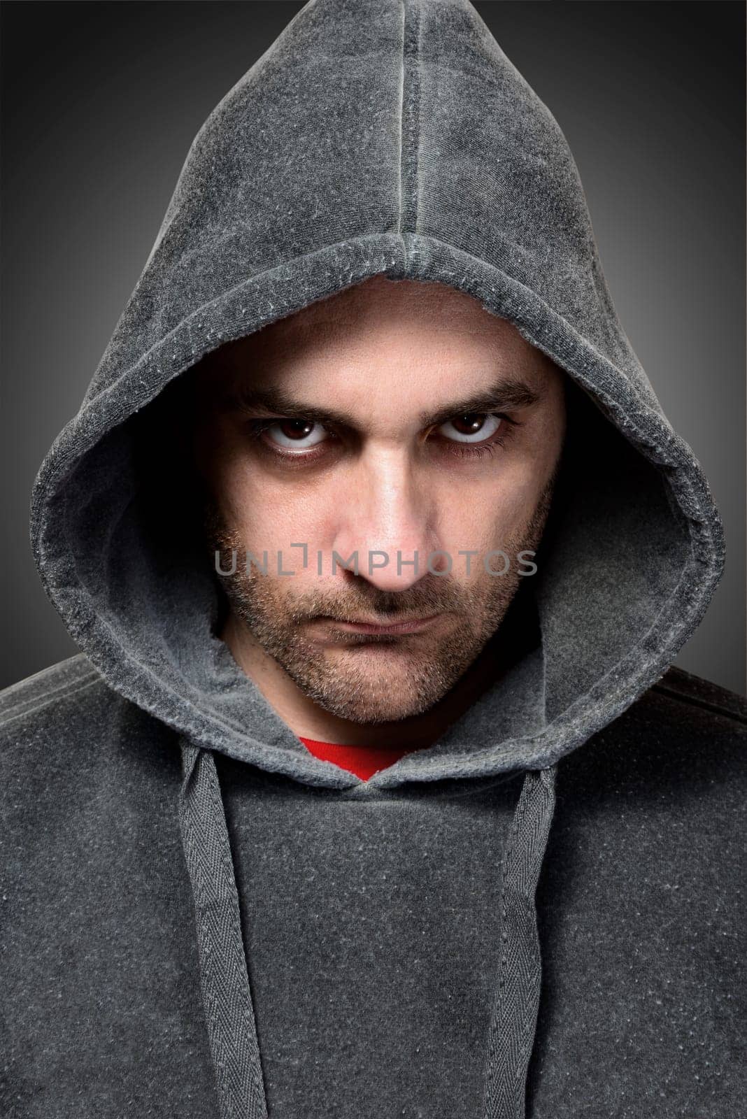 Young angry gangster with the hood on his head