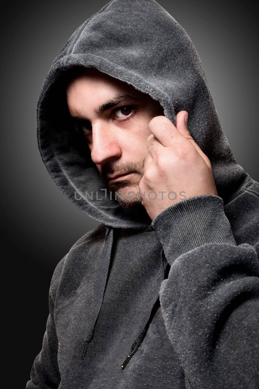 Young angry gangster with the hood on his head